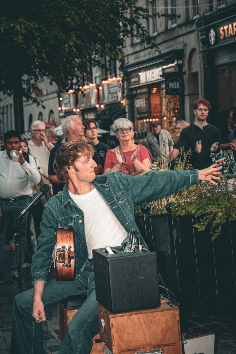 A street musician performs for a gathered crowd.