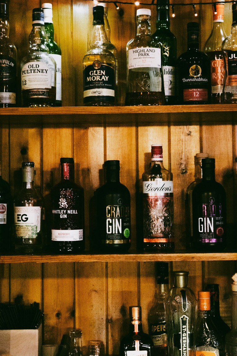 Warmly lit shelves of bottles in a traditional bar.