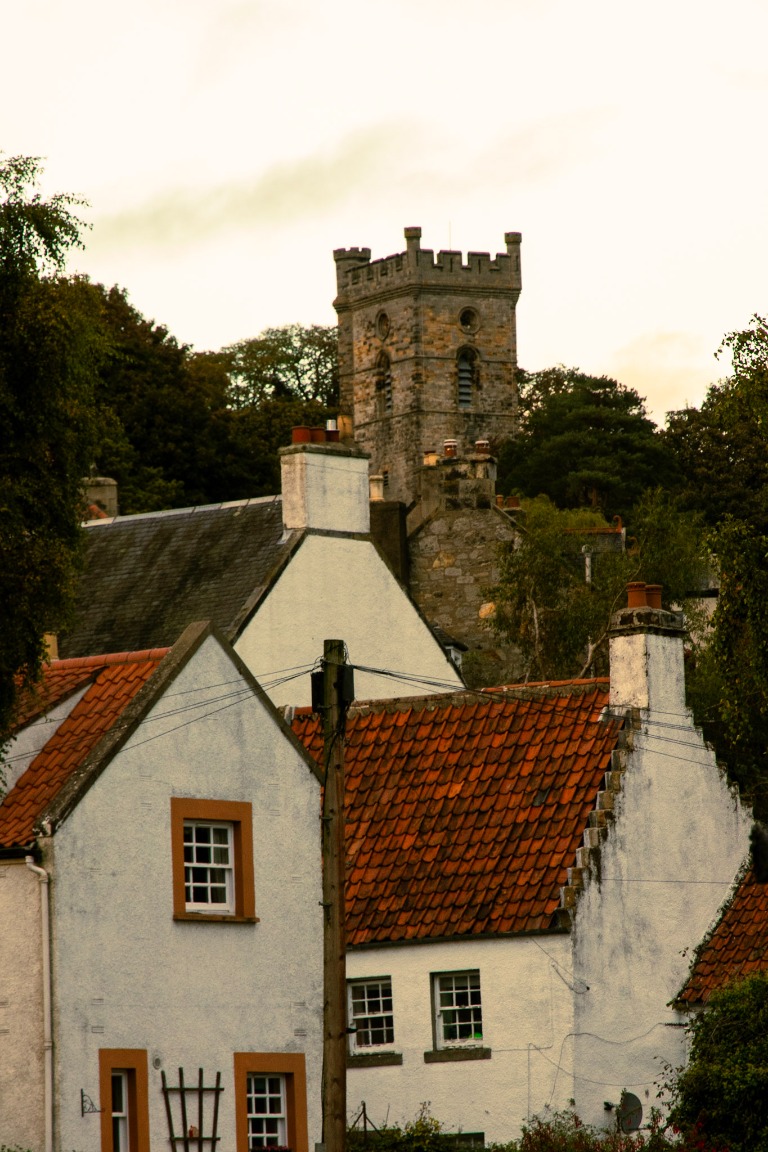 Old stone rooftops and a historic tower above the town.